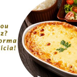Travessa com arroz de forno cremoso recém-saído do forno, com queijo derretido e gratinado por cima, em uma mesa rústica com colher de servir ao lado.