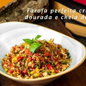 Prato de farofa dourada em uma tigela de barro com colher de madeira